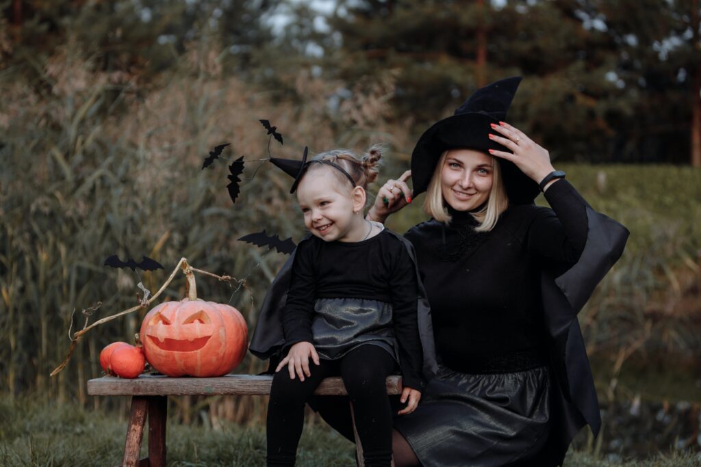 mother and daughter in costume smiling next to pumpkins after a visit with our White Lake family dentists